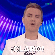 a man in a white jacket is making a funny face and says claro