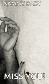 a black and white photo of a woman holding a man 's hand with the words `` miss you ! ''