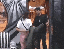 a man and a woman are standing next to each other in a room in a shopping mall .