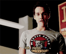 a man wearing a t-shirt that says mystic falls on it