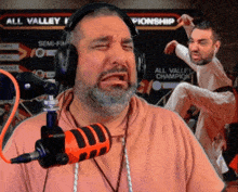 a man wearing headphones stands in front of a sign that says all valley
