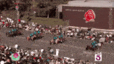 a large crowd of people watching a parade in front of a building that says norton simon museum