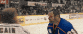 a hockey player with ball on his back stands on the ice