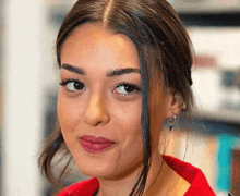 a close up of a woman 's face with a red shirt on