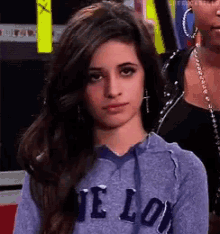 a woman is wearing a purple hoodie with the word love on it .