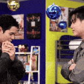 two men are standing next to each other in a room