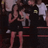 a man and a woman are dancing on a stage in front of a crowd of people .