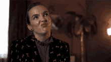 a woman in a purple jacket with horses on it is making a face .