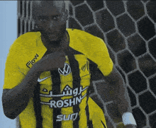 a man wearing a yellow and black shirt with the word flow on the sleeve