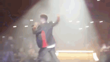 a man singing into a microphone on a stage in front of a crowd