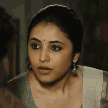 a close up of a woman 's face with a surprised expression on her face .