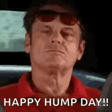 a man wearing sunglasses and a red shirt is driving a car and saying `` happy hump day ! ''