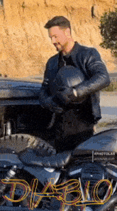 a man in a leather jacket is holding a helmet next to a motorcycle with the word diablo on the side