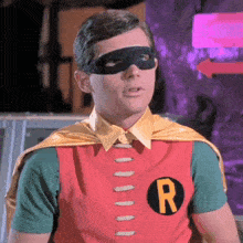 a man in a robin costume is wearing a mask and a cape