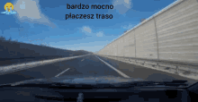 a car is driving down a highway with the words bardzo mocno placesz traso written on the bottom