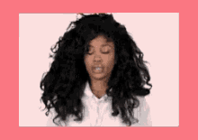 a woman with long curly hair is making a funny face .