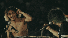 a man playing a keyboard in front of a crowd with the letter d on the bottom right