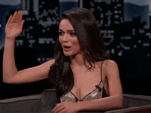 a woman sitting in a chair with her hand up