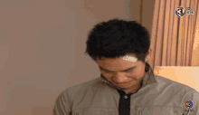 a man with a bandage on his forehead has the number 3 on the bottom right