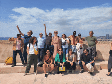 a group of people posing for a picture with one woman pointing up at the sky