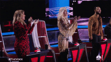 a group of people applauding on a stage with #thevoice written on the bottom right