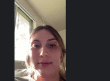 a woman 's face is shown in front of a window