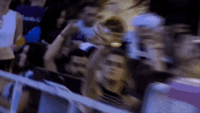 a blurry picture of a crowd of people including one wearing a purple shirt that says angels