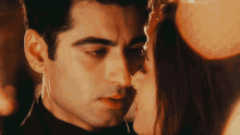 a close up of a man and woman kissing with a blurry background