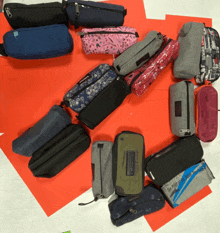 a bunch of pencil cases are lined up on a red and white carpet