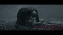 a woman is laying on the ground while a man holds her