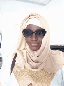 a woman wearing sunglasses and a hooded jacket is standing in front of a building that says ' bwc ' on it
