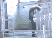 a man in a black shirt is playing a guitar in a room with white pipes