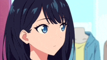 a close up of a girl 's face with blue eyes and black hair