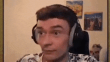 a man wearing headphones is looking at the camera .