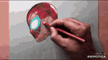 a person is drawing a spider man head with a pencil