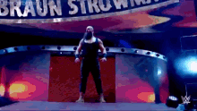 a man with a beard is standing on a stage in front of a sign that says braun strowman .