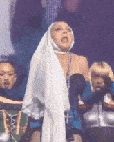 a woman is wearing a nun costume and making a funny face on stage .