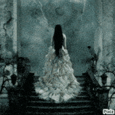 a woman in a white dress is standing on a set of stairs with pixiz written on the bottom right