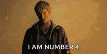 a man is standing in front of a wall with the words `` i am number 4 '' written on it .