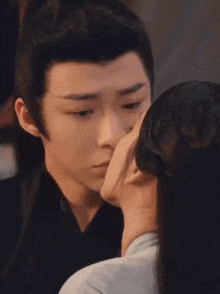 a man and a woman are kissing in a room .