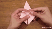 a person is holding a piece of pink paper and the words made in animotica are on the bottom