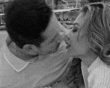 a man and a woman are kissing in front of a sign that says only snow