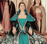 a woman in a blue dress with a crown on her head is sitting on a chair