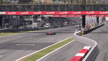 a race car is going down a track with a red banner that says sybiln