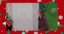 a woman wearing a plaid shirt and antlers is standing in front of a christmas backdrop .