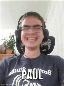 a young man wearing glasses and headphones has paul written on his shirt