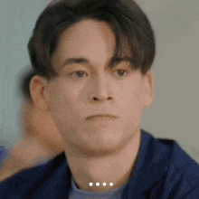a close up of a young man 's face with a blurred background .