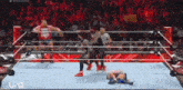 a group of wrestlers are standing in a wrestling ring with a referee .