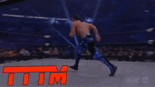 a man is laying on the ground in a wrestling ring while a crowd looks on .