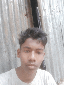 a young man taking a selfie in front of a metal fence